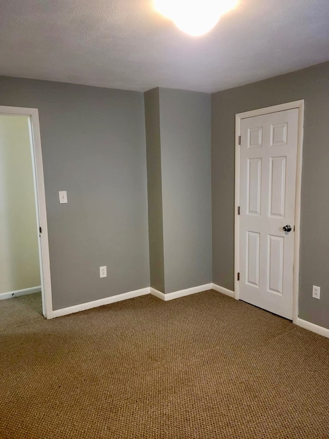 carpeted spare room featuring a textured ceiling