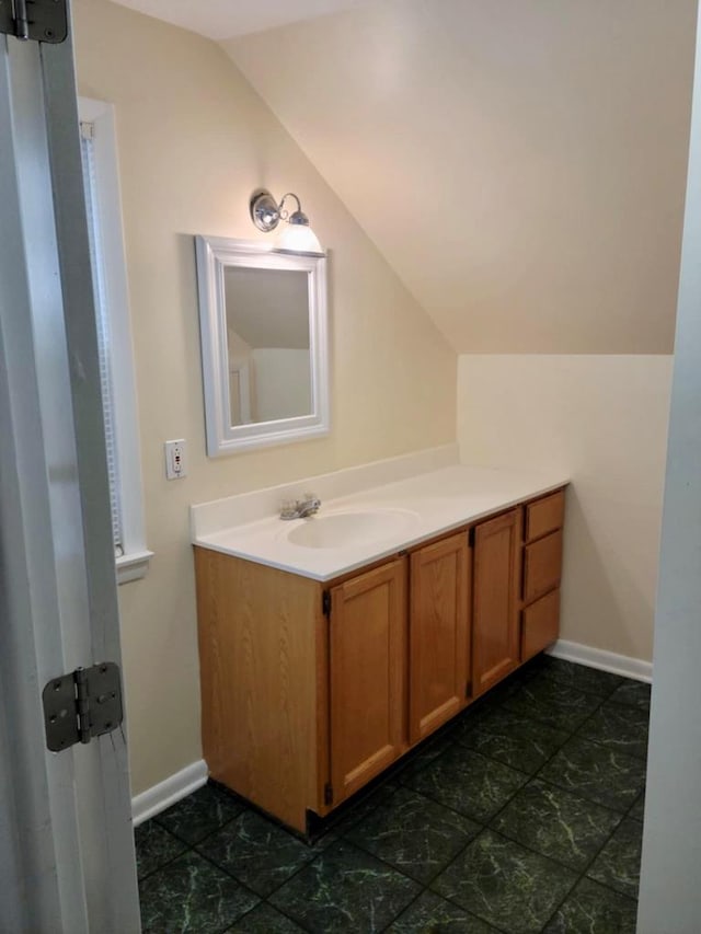 bathroom featuring vaulted ceiling and vanity