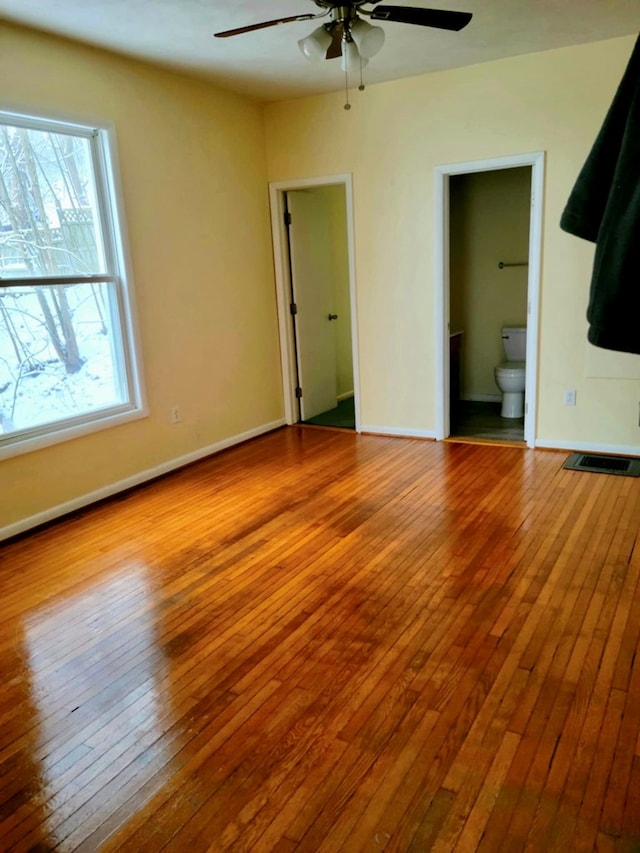 unfurnished bedroom featuring connected bathroom, ceiling fan, and light wood-type flooring