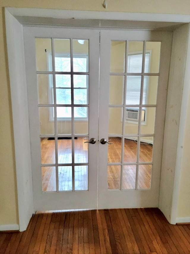 doorway to outside featuring french doors, cooling unit, and hardwood / wood-style flooring