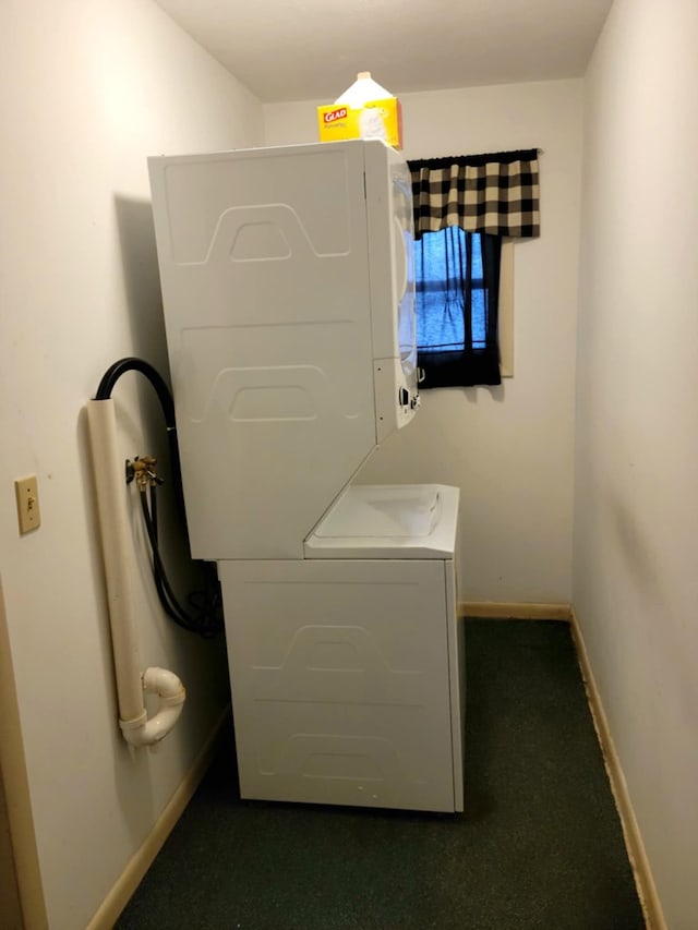 clothes washing area featuring stacked washer / drying machine and dark carpet