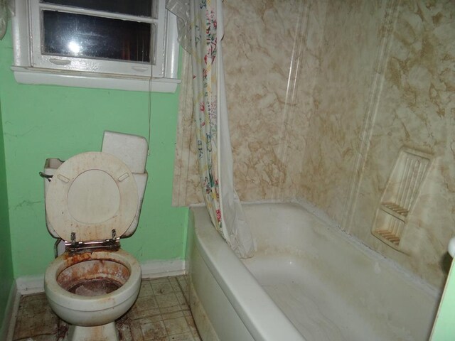 bathroom with shower / bath combo with shower curtain and toilet