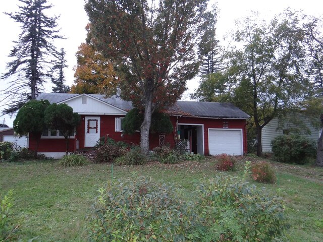 ranch-style home with a garage and a front yard