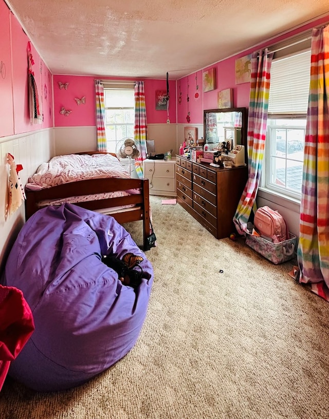 carpeted bedroom featuring multiple windows and a textured ceiling