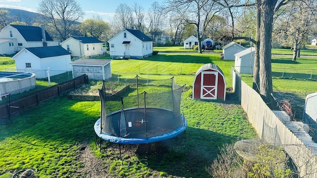 view of yard with a storage shed and a trampoline