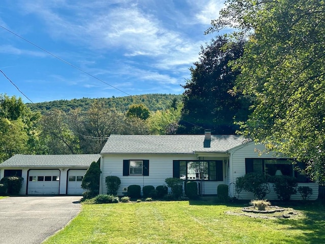 ranch-style house featuring a garage and a front yard