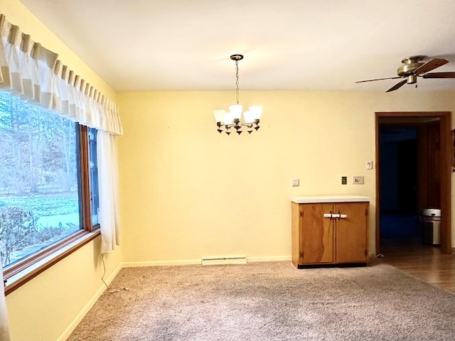 spare room featuring ceiling fan with notable chandelier, a wealth of natural light, and carpet