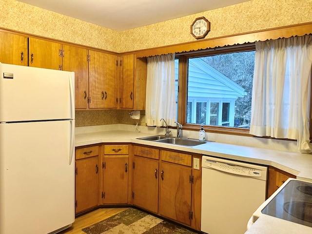 kitchen featuring sink, white appliances, and light wood-type flooring