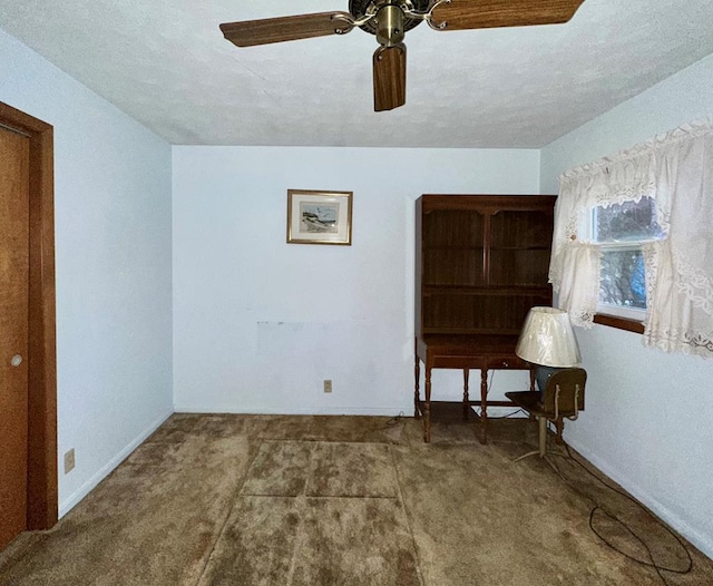 carpeted spare room with ceiling fan and a textured ceiling