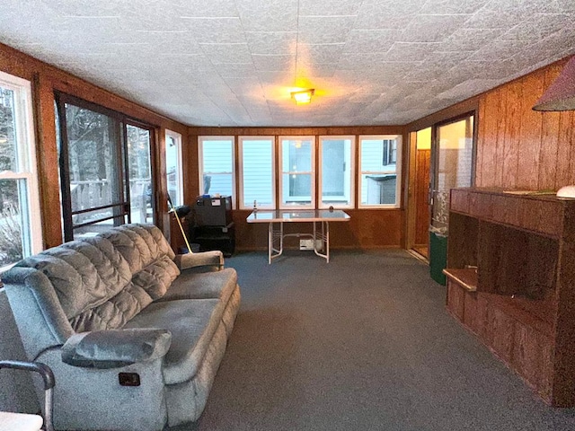 living room with carpet floors and wood walls