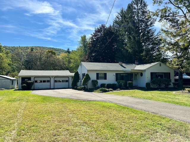 single story home featuring a garage and a front lawn