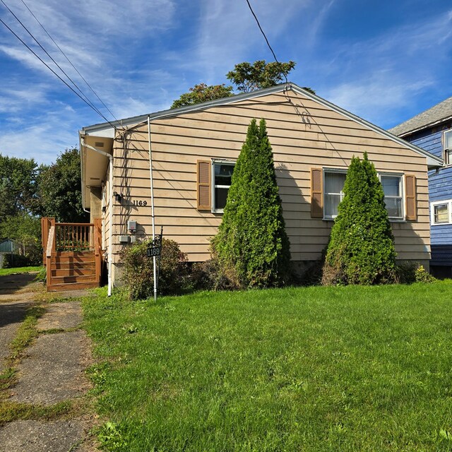 view of side of home with a yard