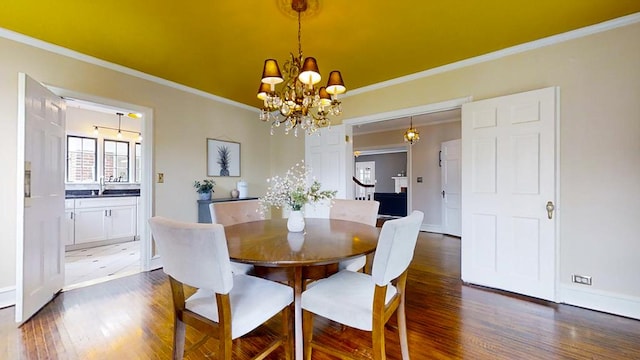 dining space featuring a notable chandelier, dark hardwood / wood-style floors, sink, and crown molding