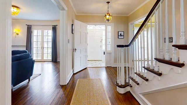 entrance foyer featuring dark hardwood / wood-style flooring, ornamental molding, and a chandelier