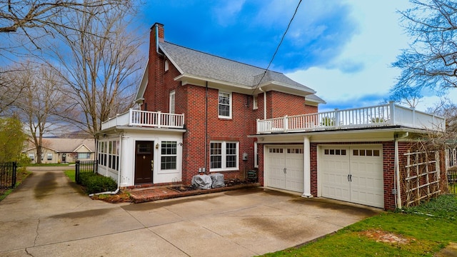 back of property with a balcony and a garage