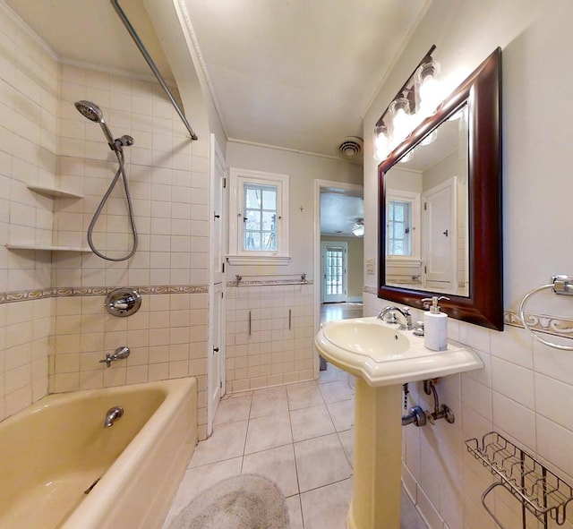 bathroom featuring tile patterned floors, tiled shower / bath combo, ornamental molding, and tile walls