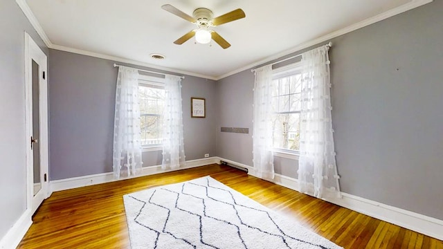 unfurnished room featuring crown molding, plenty of natural light, and hardwood / wood-style floors