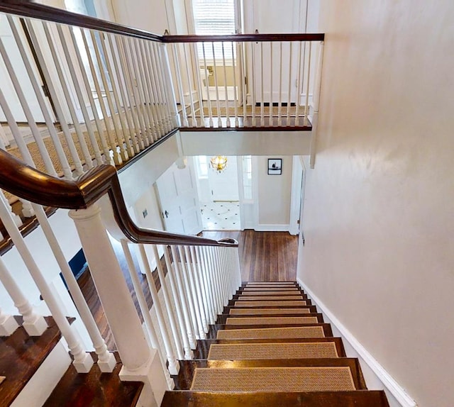 stairs with a high ceiling and hardwood / wood-style flooring