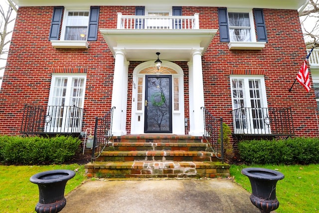 view of exterior entry with a balcony