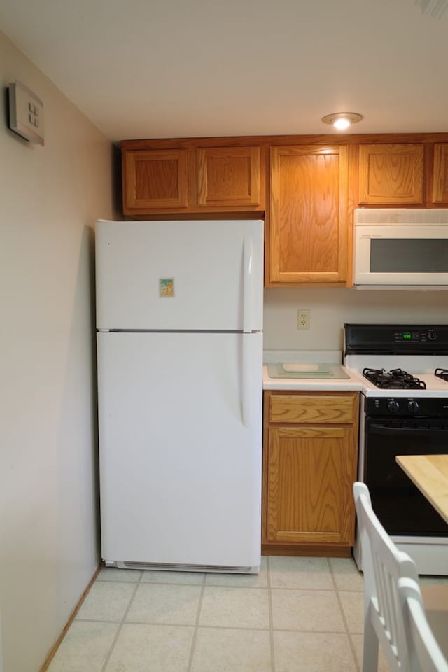 kitchen featuring light tile patterned floors and white appliances