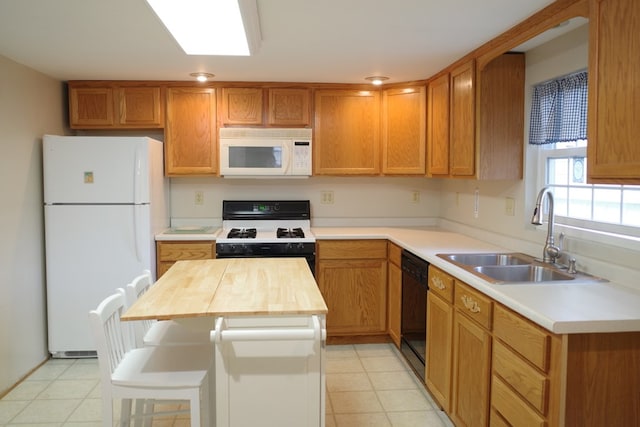 kitchen featuring a center island, sink, a breakfast bar, and white appliances