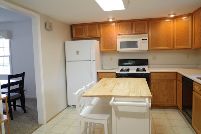 kitchen with wood counters, a kitchen island, and white appliances