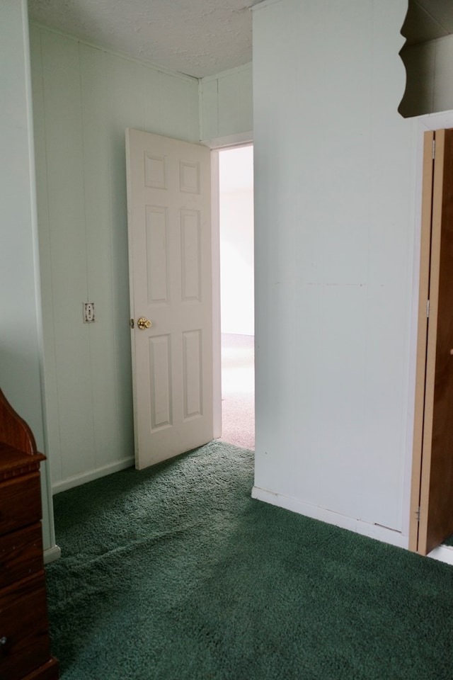 unfurnished room featuring a textured ceiling and dark colored carpet