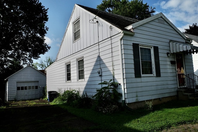 view of side of home with an outdoor structure, a garage, and a lawn