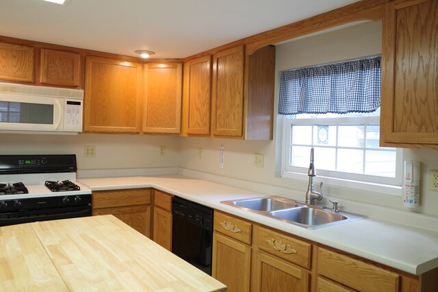 kitchen featuring sink, black appliances, and wood counters