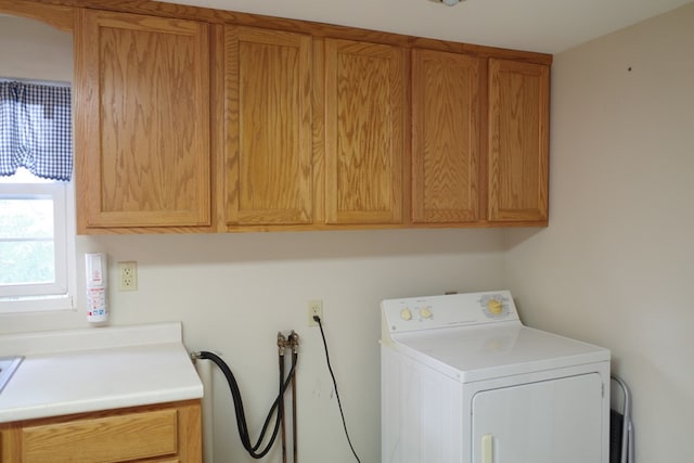 clothes washing area featuring cabinets and washer / clothes dryer