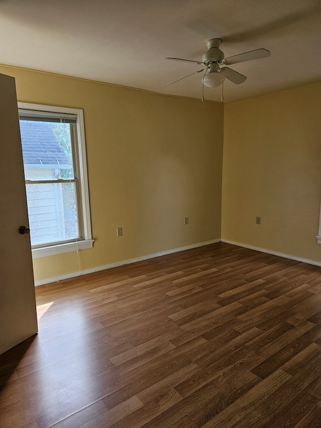 spare room featuring dark wood-type flooring and ceiling fan