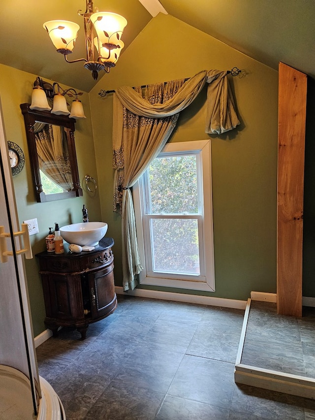 bathroom with vanity, a notable chandelier, and vaulted ceiling