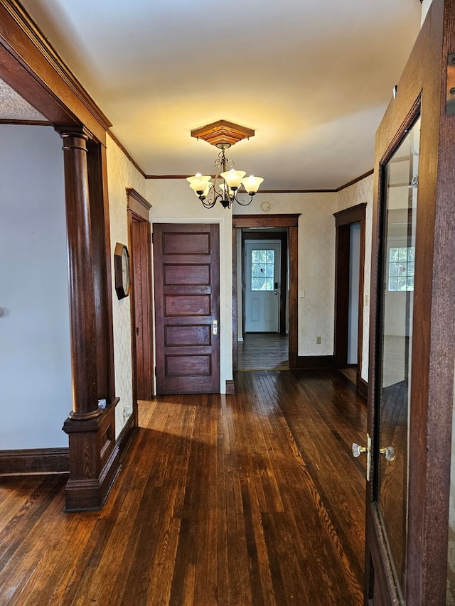 hallway with ornate columns, crown molding, plenty of natural light, and dark wood-type flooring