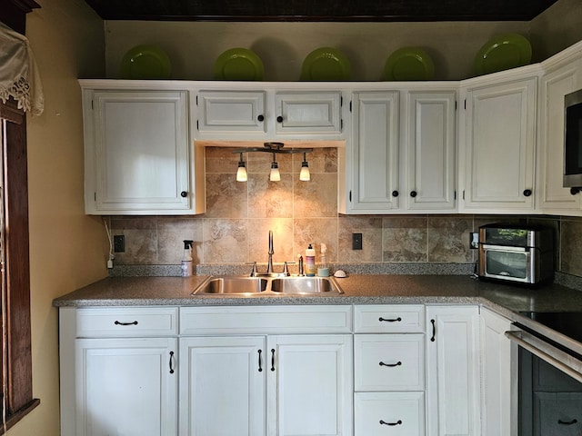 kitchen featuring sink, decorative backsplash, and white cabinets