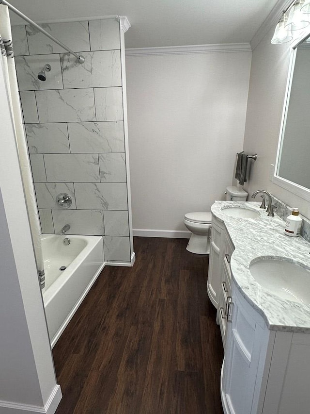 full bathroom featuring vanity, hardwood / wood-style flooring, tiled shower / bath combo, and crown molding