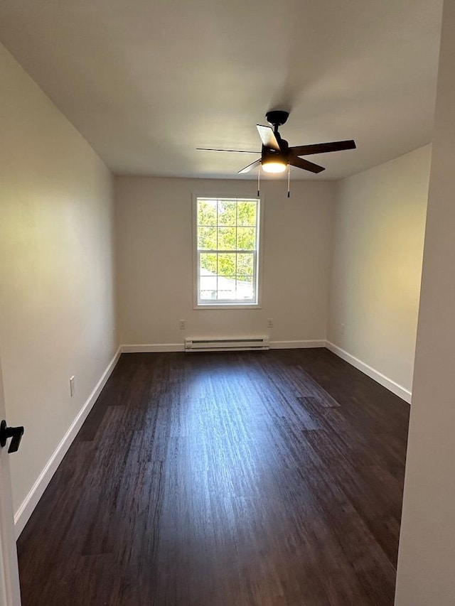 spare room with baseboard heating, ceiling fan, and dark hardwood / wood-style flooring