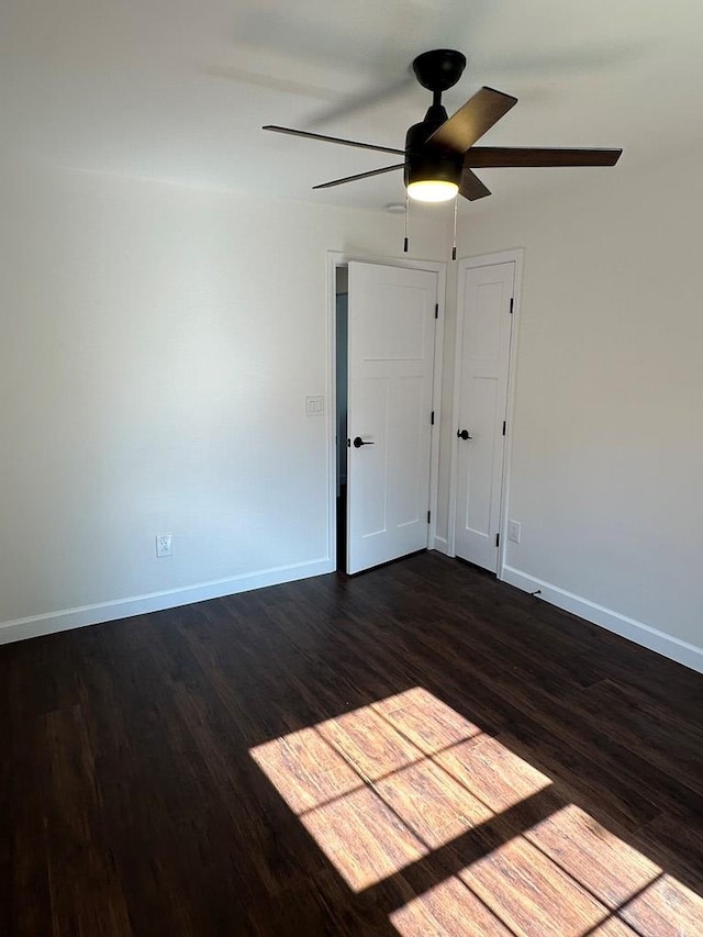 spare room with dark hardwood / wood-style flooring and ceiling fan