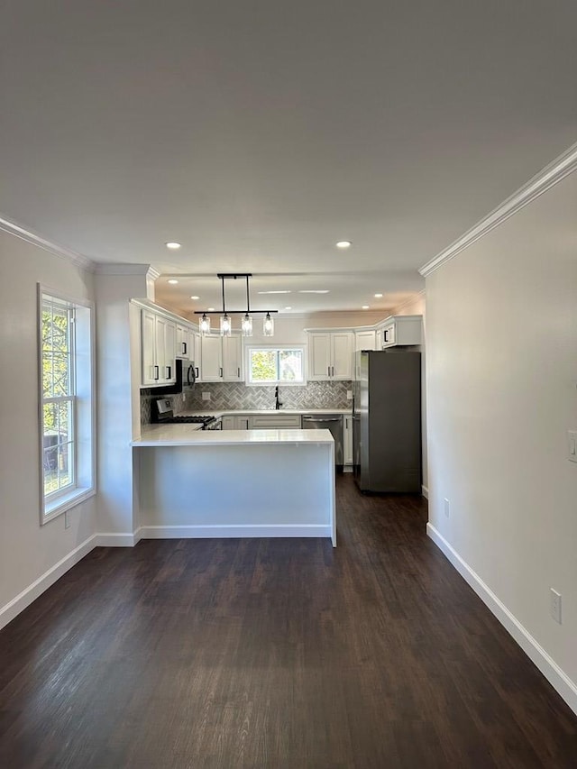 kitchen with white cabinets, a wealth of natural light, hanging light fixtures, and appliances with stainless steel finishes