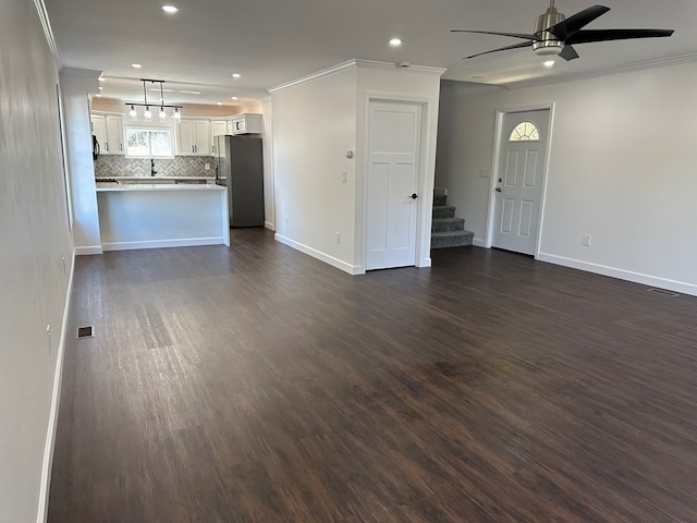 unfurnished living room featuring dark hardwood / wood-style floors, ceiling fan, and crown molding