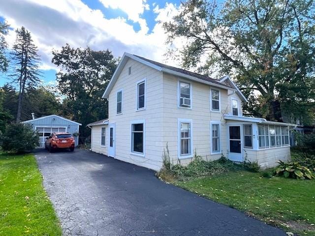 view of front of house featuring a sunroom and a front yard