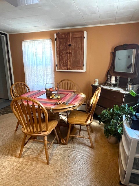 carpeted dining room featuring crown molding