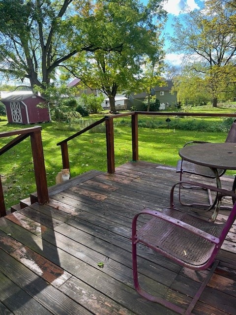 wooden terrace featuring a storage shed and a yard