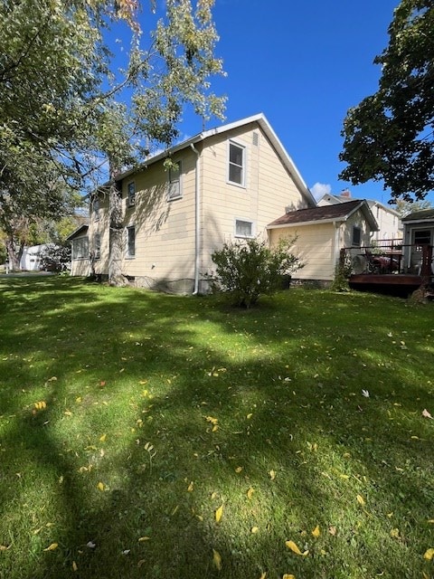 view of property exterior with a deck and a yard