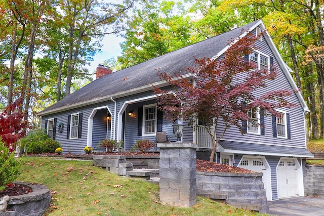 view of front facade with a porch, a garage, and a front yard