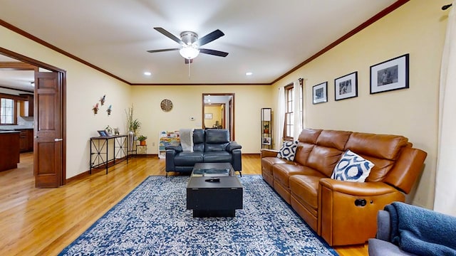 living room with hardwood / wood-style flooring, ceiling fan, and crown molding