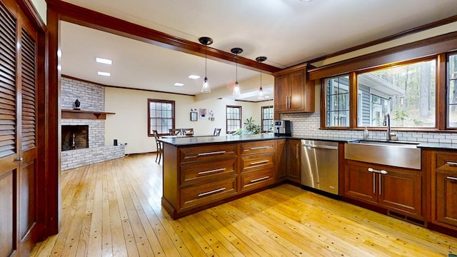 kitchen featuring dishwasher, hanging light fixtures, light hardwood / wood-style flooring, plenty of natural light, and kitchen peninsula