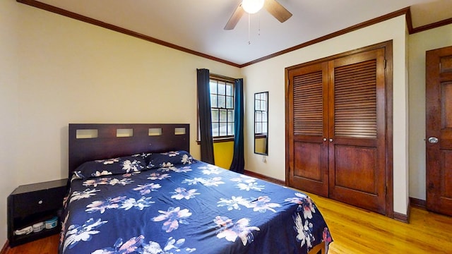 bedroom featuring a closet, hardwood / wood-style flooring, ceiling fan, and crown molding