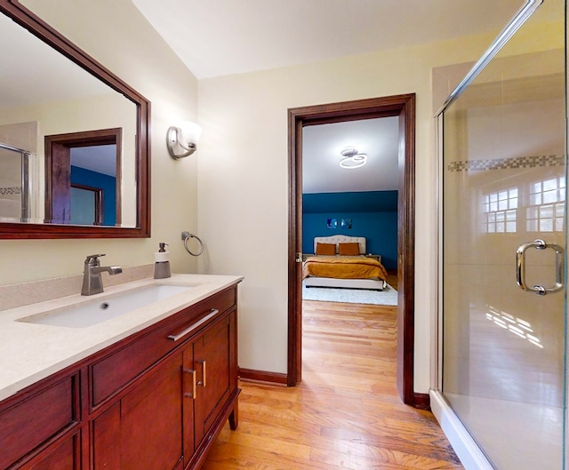 bathroom featuring hardwood / wood-style floors, vanity, and a shower with shower door