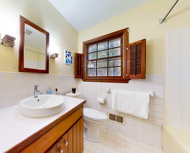 full bathroom featuring shower / bathing tub combination, vanity, tile patterned flooring, toilet, and tile walls