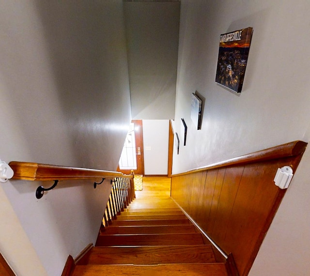 staircase featuring wood walls and hardwood / wood-style floors